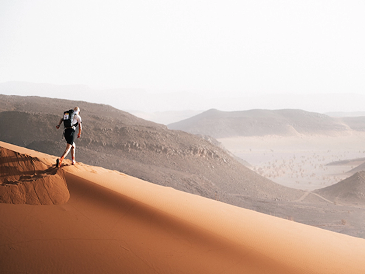 Marathon des Sables ronde zand duin met marathon loper erop