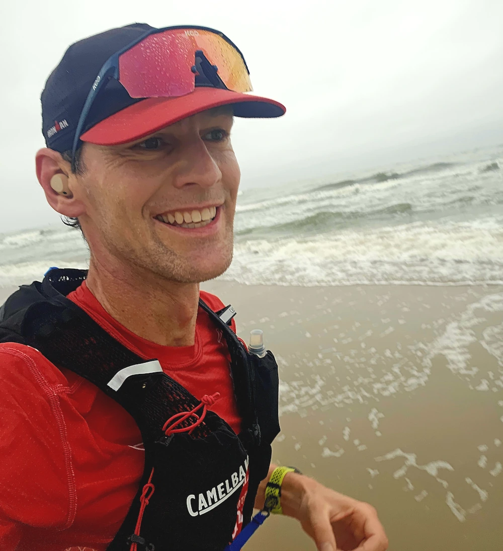 Peter met de hardloop Rugzak tijdens hardlopen op het strand